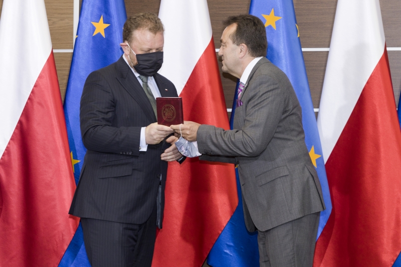 Łukasz Szumowski odbiera Medal od Andrzeja Tykarskiego